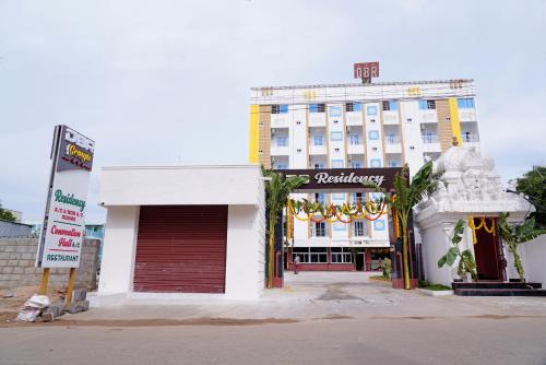 a white building with a sign in front of it at Devansh Bhanu Residency DBR in Srikalahasti