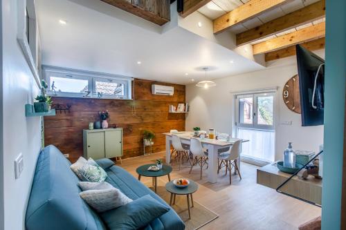 un salon avec un canapé bleu et une table dans l'établissement Gîte La Rodernelle - Sauna - Patio - Climatisation - Vue sur Château du Haut Kœnigsbourg, à Rodern