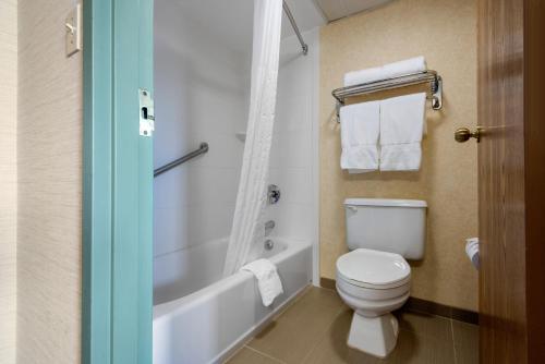 a bathroom with a toilet and a tub and a sink at Quality Inn & Suites in Mansfield