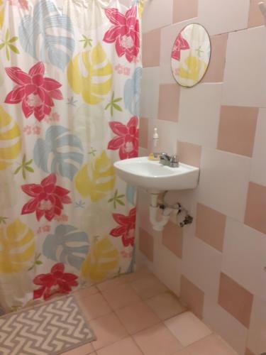 a bathroom with a sink and a shower curtain at Thelmar Rooms Cancun in Cancún