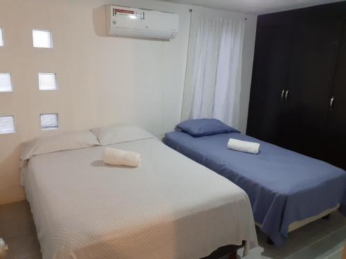 2 nebeneinander sitzende Betten in einem Schlafzimmer in der Unterkunft Thelmar Rooms Cancun in Cancún
