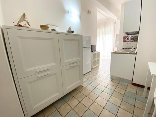 a kitchen with white cabinets and a tiled floor at Il Viaggiatore Serapo in Gaeta