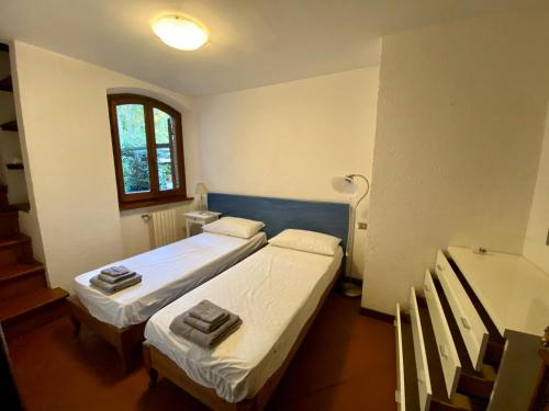 Duas camas num pequeno quarto com uma janela em Perfetta per la Famiglia em Pietrasanta
