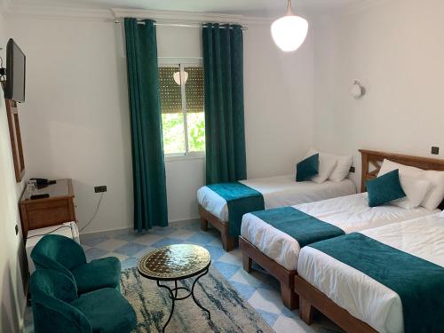 a hotel room with two beds and a chair at Marco Polo in Tangier