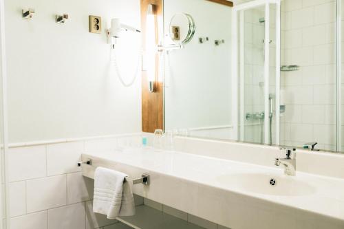 a white bathroom with a sink and a mirror at Holiday Club Åre in Åre