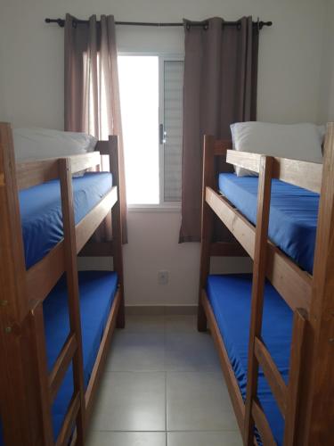 2 Etagenbetten in einem Zimmer mit Fenster in der Unterkunft Apartamentos Gratitude in Ubatuba