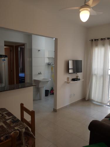 a living room with a sink and a television at Apartamentos Gratitude in Ubatuba