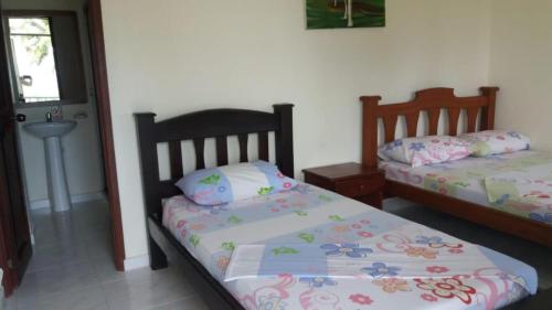 een slaapkamer met 2 aparte bedden en een raam bij Hotel Reserva Aguamarina in Playa Ladrilleros