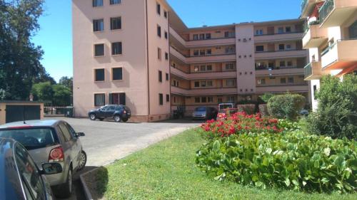 a large pink building with cars parked in a parking lot at Turgot bleu in Thonon-les-Bains