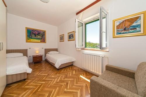 ein Zimmer mit 2 Betten und einem Sofa darin in der Unterkunft Villa Živana in Dugi Rat
