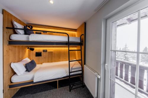 two bunk beds in a room with a window at Villars Lodge in Villars-sur-Ollon