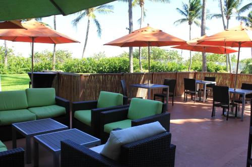 a patio with tables and chairs and umbrellas at Holiday Inn Miami Beach-Oceanfront by IHG in Miami Beach