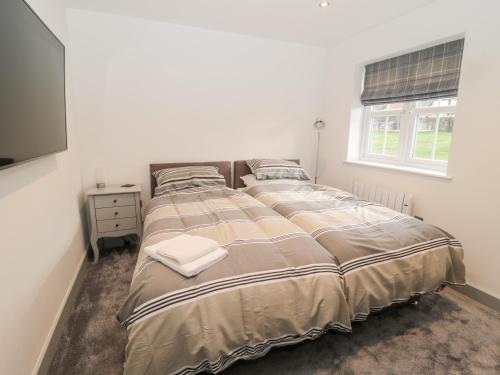 a bedroom with a large bed and a television at 11 The Forge in Brampton