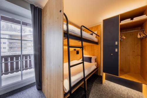 a room with two bunk beds and a window at Villars Lodge in Villars-sur-Ollon