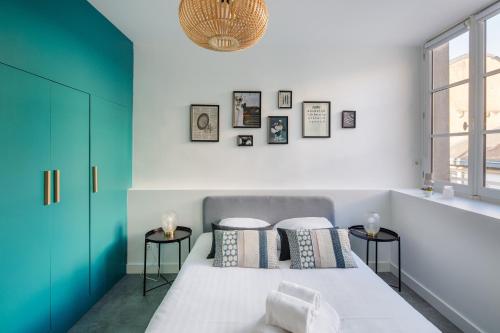 1 dormitorio con 1 cama con 2 taburetes en Le Pommeraye - Coeur de ville en Nantes