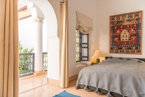 um quarto com uma cama e um grande tapete na parede em Riyad El Cadi em Marrakech