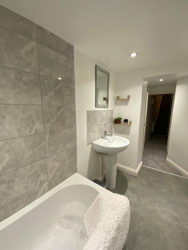 a bathroom with a bath tub and a sink at The Hidden Nook in Whitby
