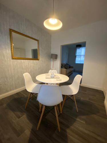 uma sala de jantar com uma mesa, cadeiras e um espelho em The Hidden Nook em Whitby