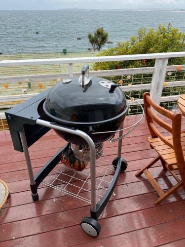 a grill sitting on a deck next to a chair at Departamento Frente al Mar in Concón