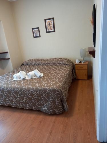 a bedroom with a bed and a wooden floor at Hotel Hawaii in Mar del Plata