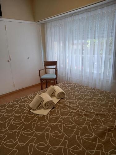 a room with a bed with a chair and a window at Hotel Hawaii in Mar del Plata