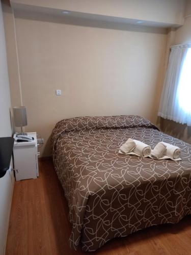 a bedroom with a bed with two towels on it at Hotel Hawaii in Mar del Plata