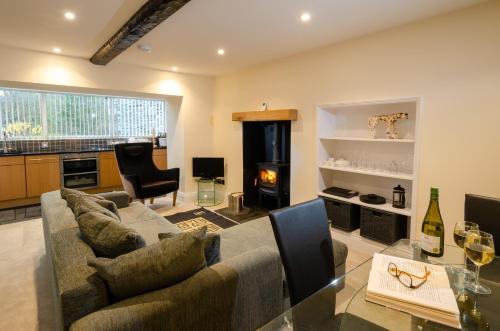 a living room with a couch and a glass table at Anns Cottage, Chapel Stile in Chapel Stile