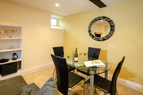 a dining room with a glass table and black chairs at Anns Cottage, Chapel Stile in Chapel Stile