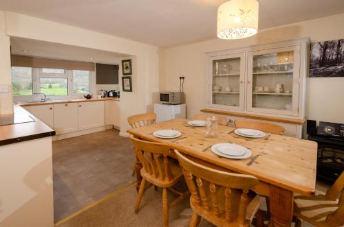 a kitchen and dining room with a wooden table and chairs at Langdale Hideaway in Chapel Stile