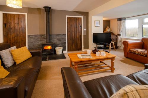 a living room with a couch and a fireplace at Langdale Hideaway in Chapel Stile