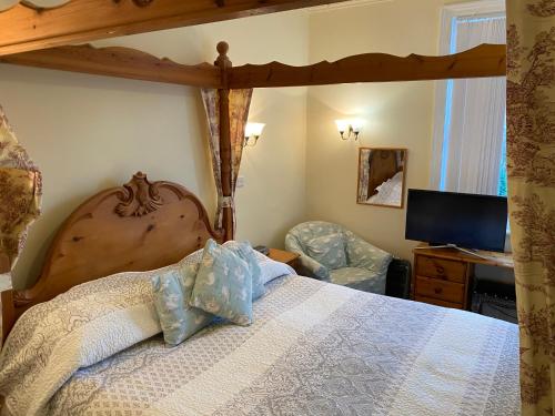 a bedroom with a bed and a desk with a computer at The Old Manse Pickering in Pickering