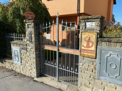 a gate with a sign in front of a building at LA SISMONDA in Rodello
