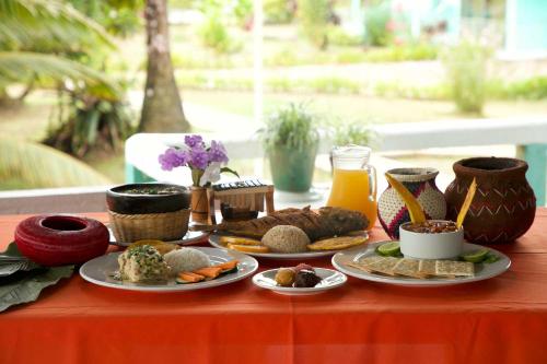 una mesa con platos de comida en una mesa roja en Hotel Costa Real, en Playa Ladrilleros