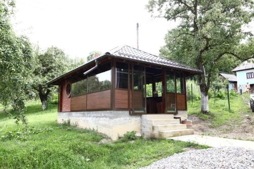 un piccolo edificio in un campo alberato di Hățașul Bunicului a Arefu