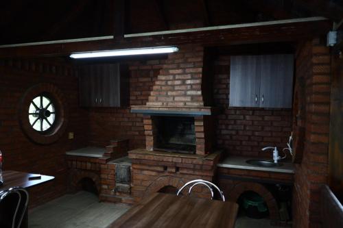 a kitchen with a brick fireplace and a sink at Hățașul Bunicului in Arefu