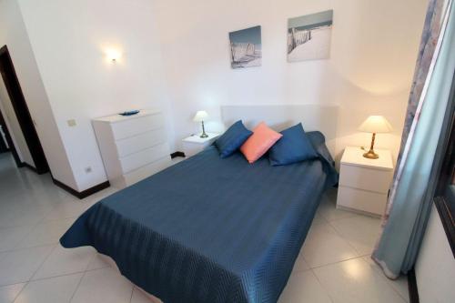 een slaapkamer met een blauw bed met 2 kussens bij Vilamouratenis 'Blue' by SAPvillas in Vilamoura