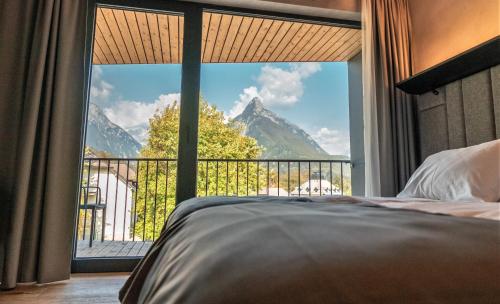 a bedroom with a large window with a mountain view at Hotel Soča in Bovec