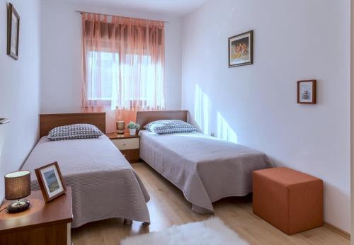 1 Schlafzimmer mit 2 Betten, einem Tisch und einem Fenster in der Unterkunft Apartments Amari in Kaštela