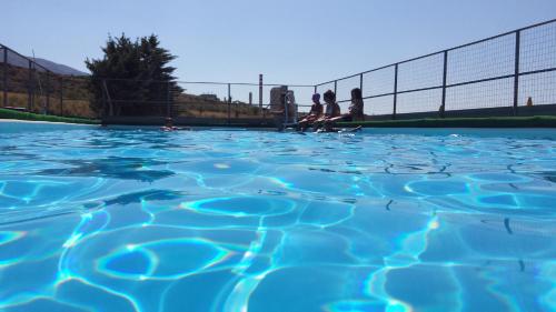 een zwembad van blauw water met twee personen op de achtergrond bij Zio Mario e Zia Maria - Casa Vacanze e Affitti brevi in Castrovillari