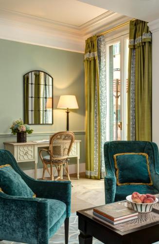 a living room with two chairs and a table at Rocco Forte Hotel De La Ville in Rome