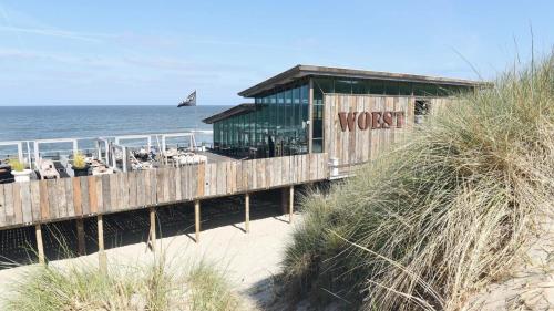 a wooden building on the beach near the ocean at B&B de Keinsmer in 't Zand