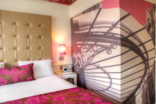 a bedroom with a bed and a wall with ainding sqor at Hotel Indigo Glasgow by IHG in Glasgow