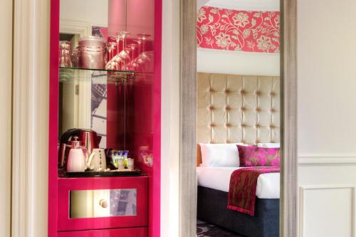 a room with a bed with a mirror and a pink bedroom at Hotel Indigo Glasgow by IHG in Glasgow
