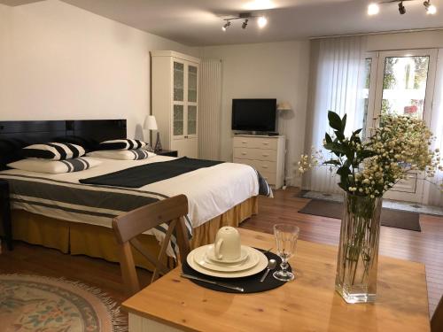 a bedroom with a bed and a table with a vase of flowers at Le studio Chez Marilé in Bry-sur-Marne