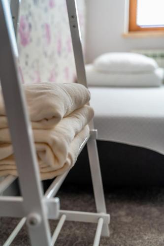 a chair with a blanket on it next to a bed at Willa Sulimówka - Noclegi Zakliczyn dom basen bania sauna SPA in Zakliczyn