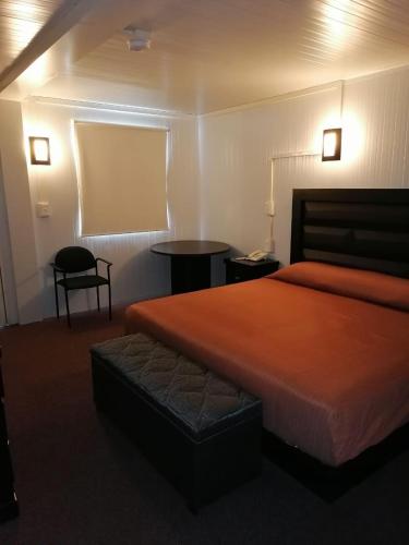 a hotel room with a bed and a chair at BONITTO INN® Monterrey Norte in Monterrey