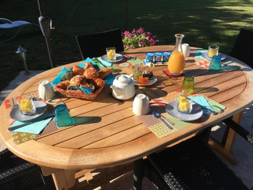 een houten tafel met een mand met eten erop bij Les Trois Provinces in Couffy