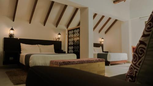 a hotel room with two beds and a couch at Termales Santa Rosa De Cabal in Santa Rosa de Cabal