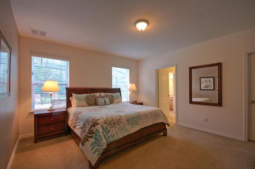 a bedroom with a bed and a lamp and a window at South Facing Pool Near Disney 5 Bed Luxury in Kissimmee