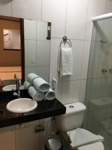 a bathroom with a sink and a toilet and a mirror at Abolição Praia Hotel in Fortaleza